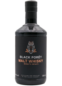 Schwarze Whiskyflasche mit Etikett und Eulenillustration.