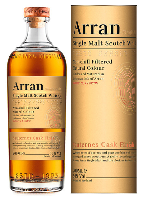 Eine Flasche Arran Single Malt Scotch Whisky und ihr zylindrischer Karton, beide mit goldener Beschriftung auf beigem Hintergrund.