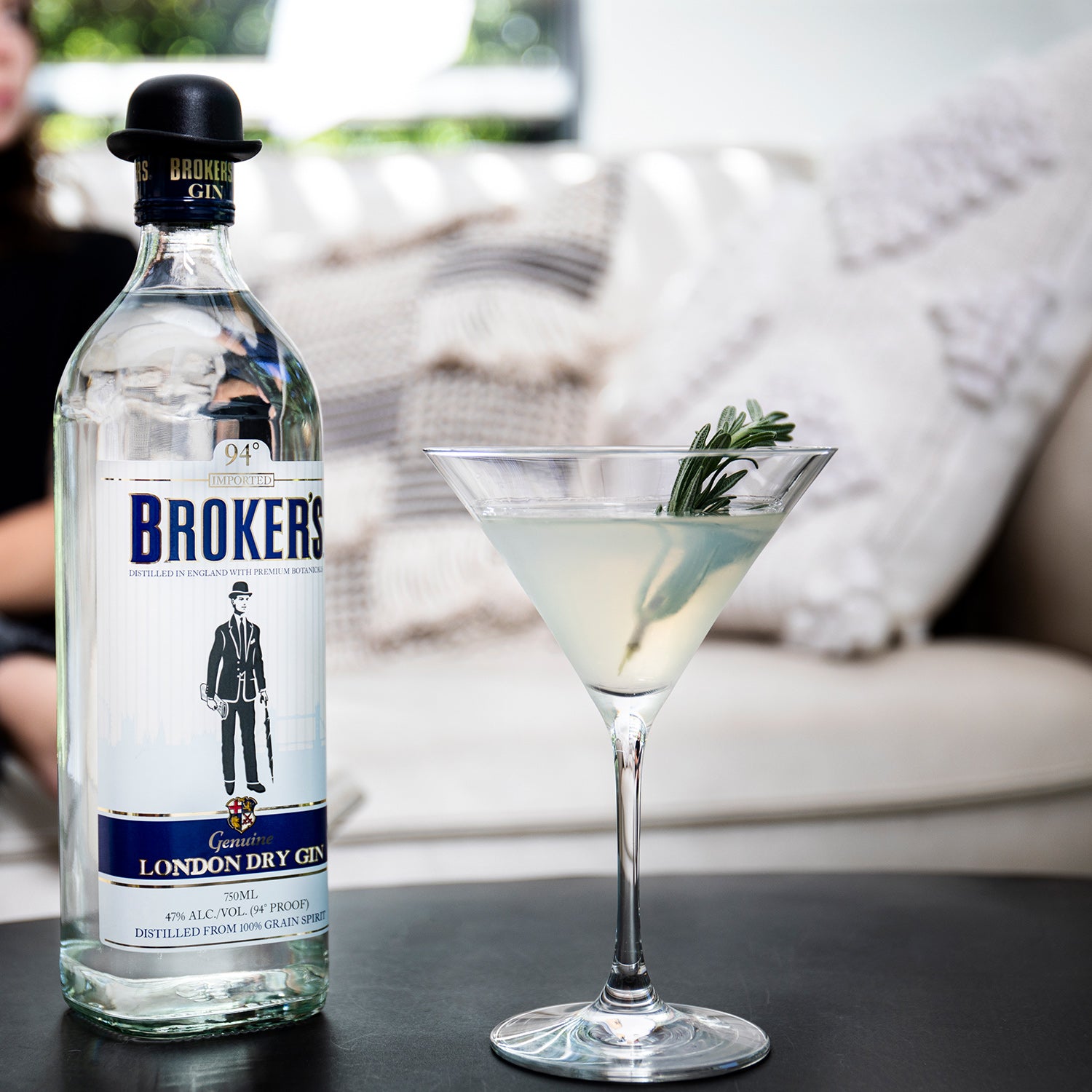 Eine Flasche Broker's London Dry Gin und ein Cocktailglas mit einem Getränk und einem Rosmarinzweig als Garnierung.
