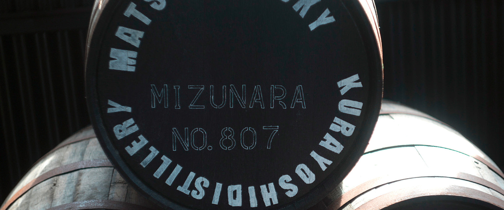 Ein Fass mit der Aufschrift "Mizunara No. 807" und "Kurayoshi Distillery" in einer Lagerhalle.