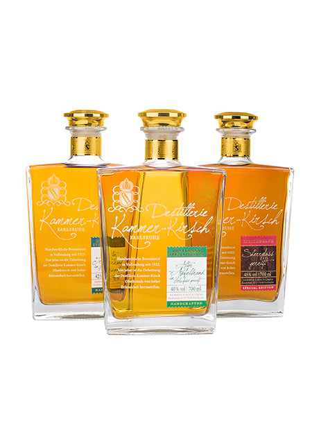 Drei Flaschen Kammer-Kirsch Spirituosen mit goldenen Verschlüssen.