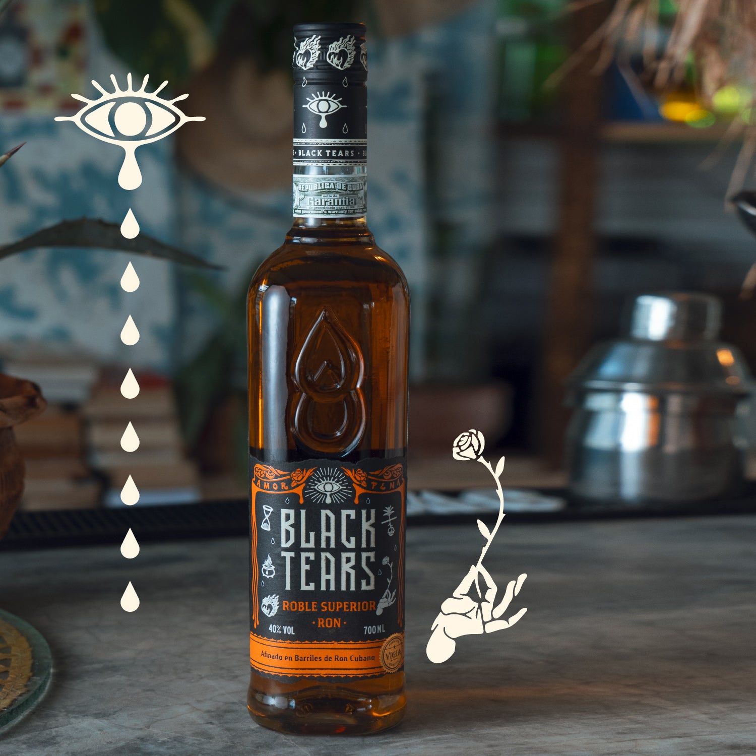 Eine Flasche "Black Tears" Rum steht auf einem Tisch mit grafischen Illustrationen eines Auges und einer Rose.