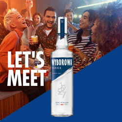 Werbung für Wyborowa Vodka mit einer Gruppe von Menschen, die zusammen feiern, und einer großen Vodka-Flasche im Vordergrund.