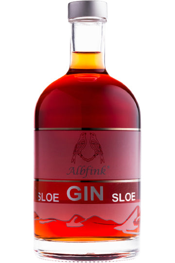 Eine Flasche Schlehengin mit rubinroter Flüssigkeit und silbernem Verschluss.