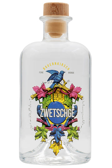 Eine klare Flasche Obstbrand mit einem bunten Etikett, das "Zwetschge" und eine Illustration von Blättern und einem Vogel zeigt.